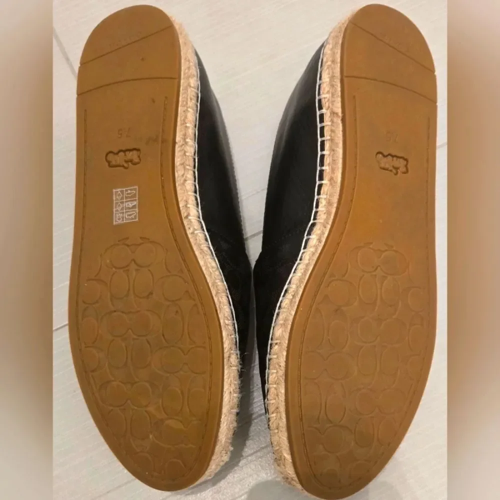 Coach Carley Black leather Espadrille Slip-On Shoes with Coach design on top.